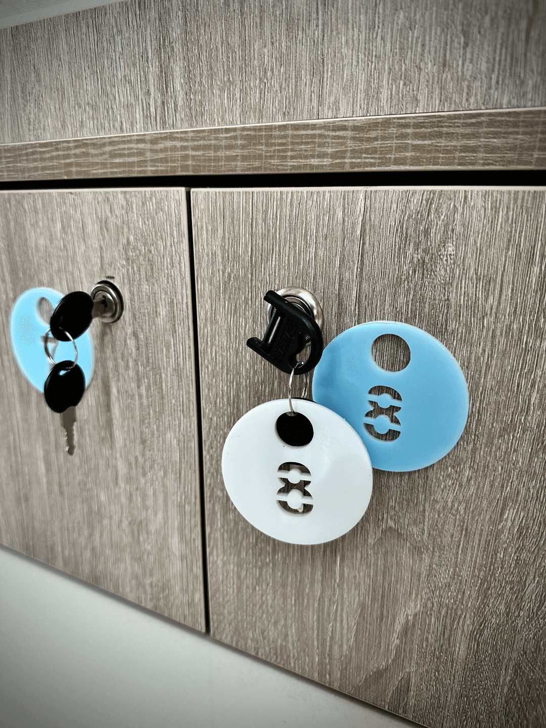 A photograph of personal lockers and keys with blue and white key tags at InterCube hostel in Dubai