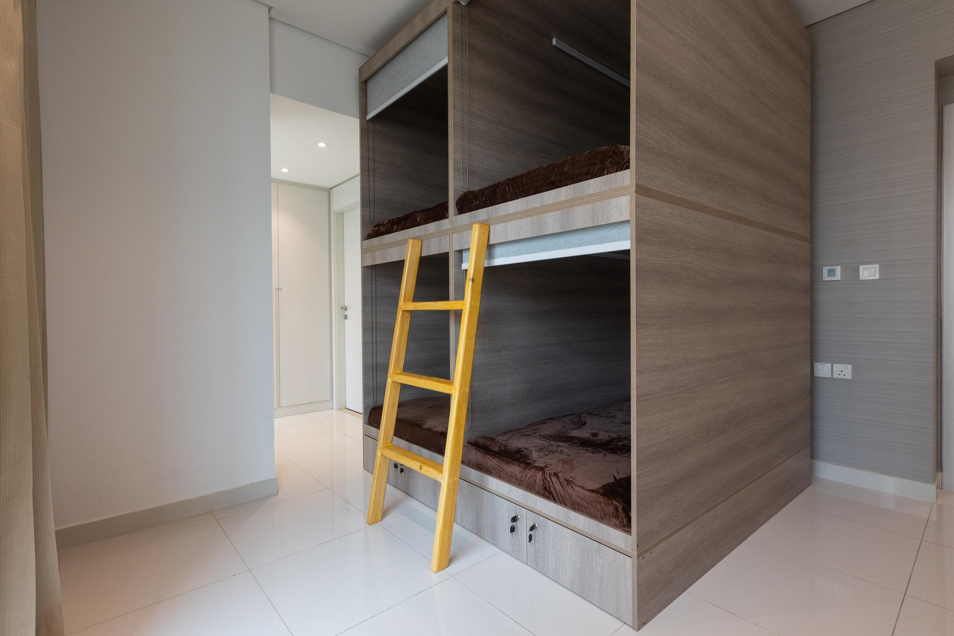 Photograph of private sleeping capsules with a ladder at InterCube hostel in Dubai, designed to offer comfort and privacy for travelers