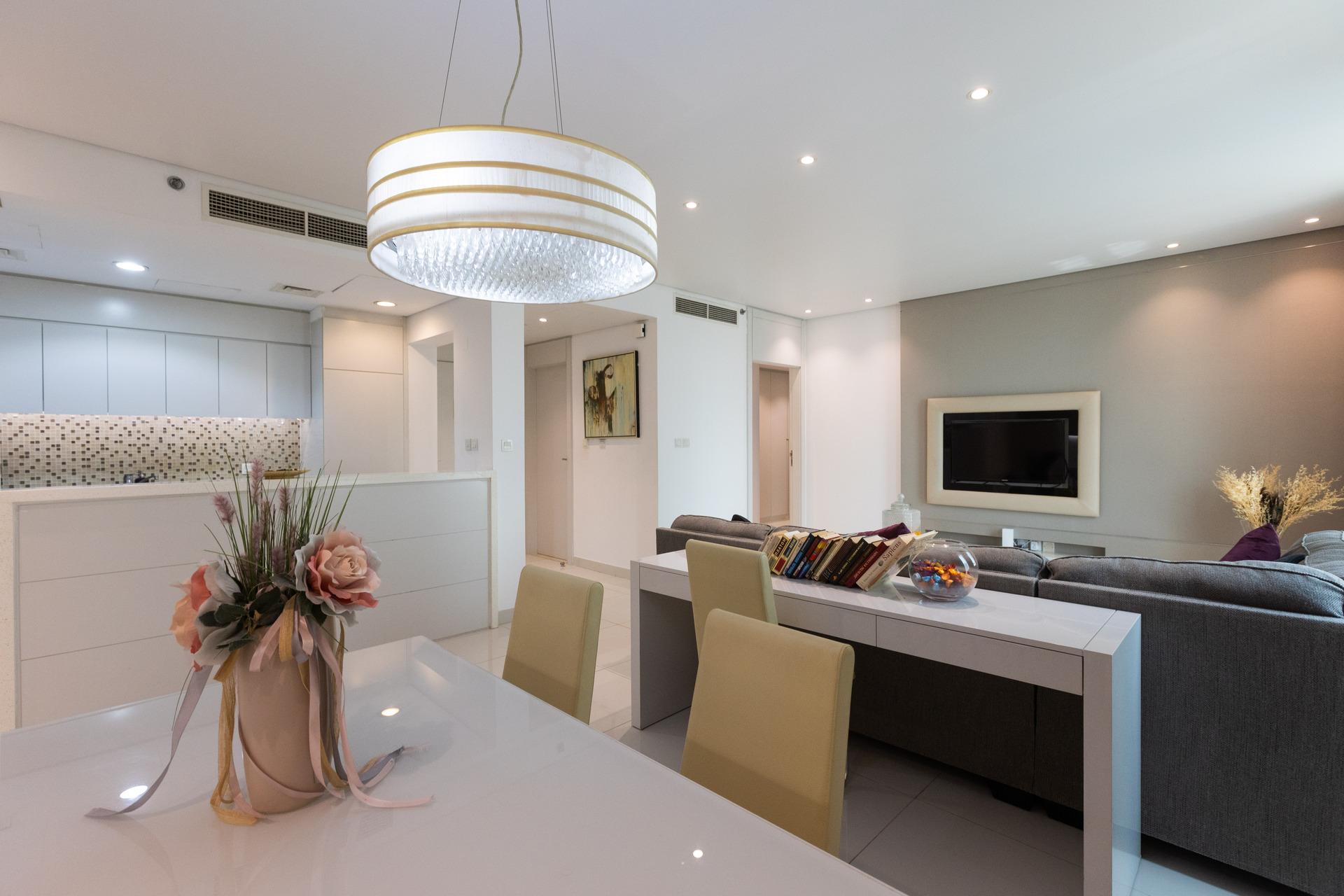 Photograph of a modern living and dining area at InterCube hostel in Dubai, featuring a sleek dining table, a cozy seating area, and a wall-mounted television